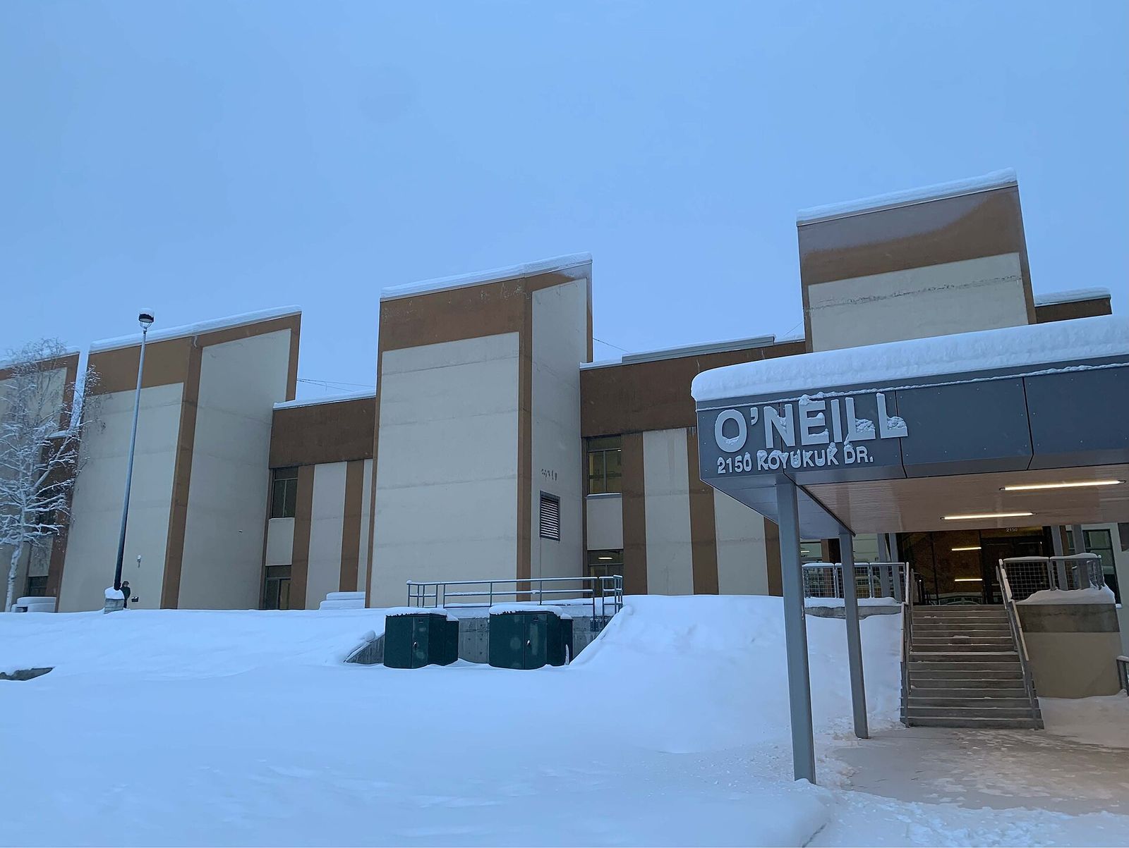 The O'Neill Building at the University of Alaska Fairbanks with snow piled along the entrance in midwinter
