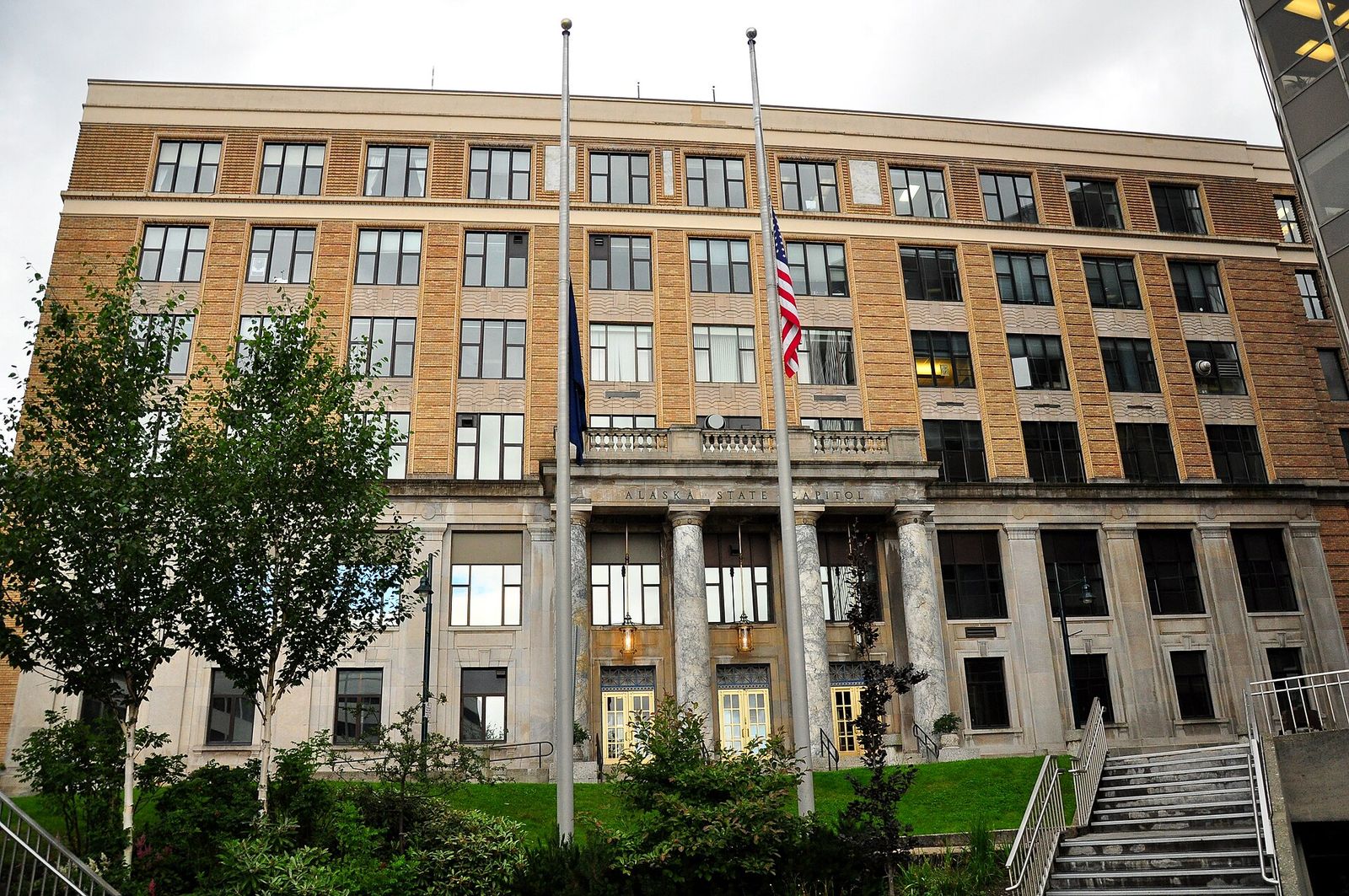 The Alaska State Capitol in Juneau, with its columned entrance and flags flying out front