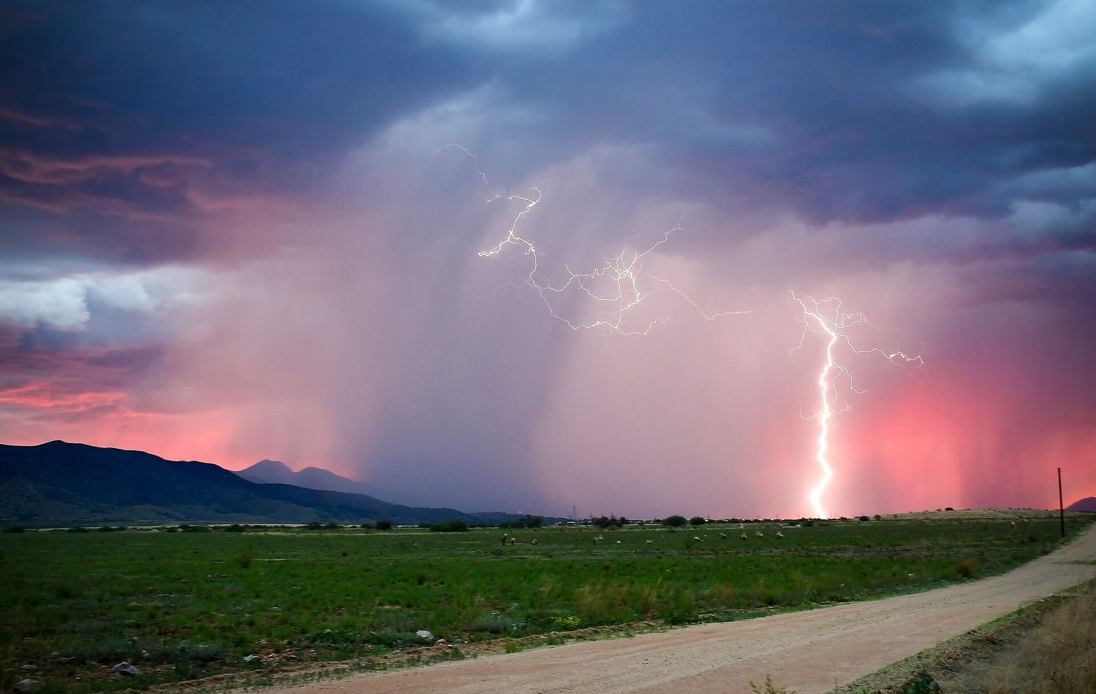 Afternoon thunderstorms with lightning moving over the Huachuca Mountains toward Sierra Vista at sunset