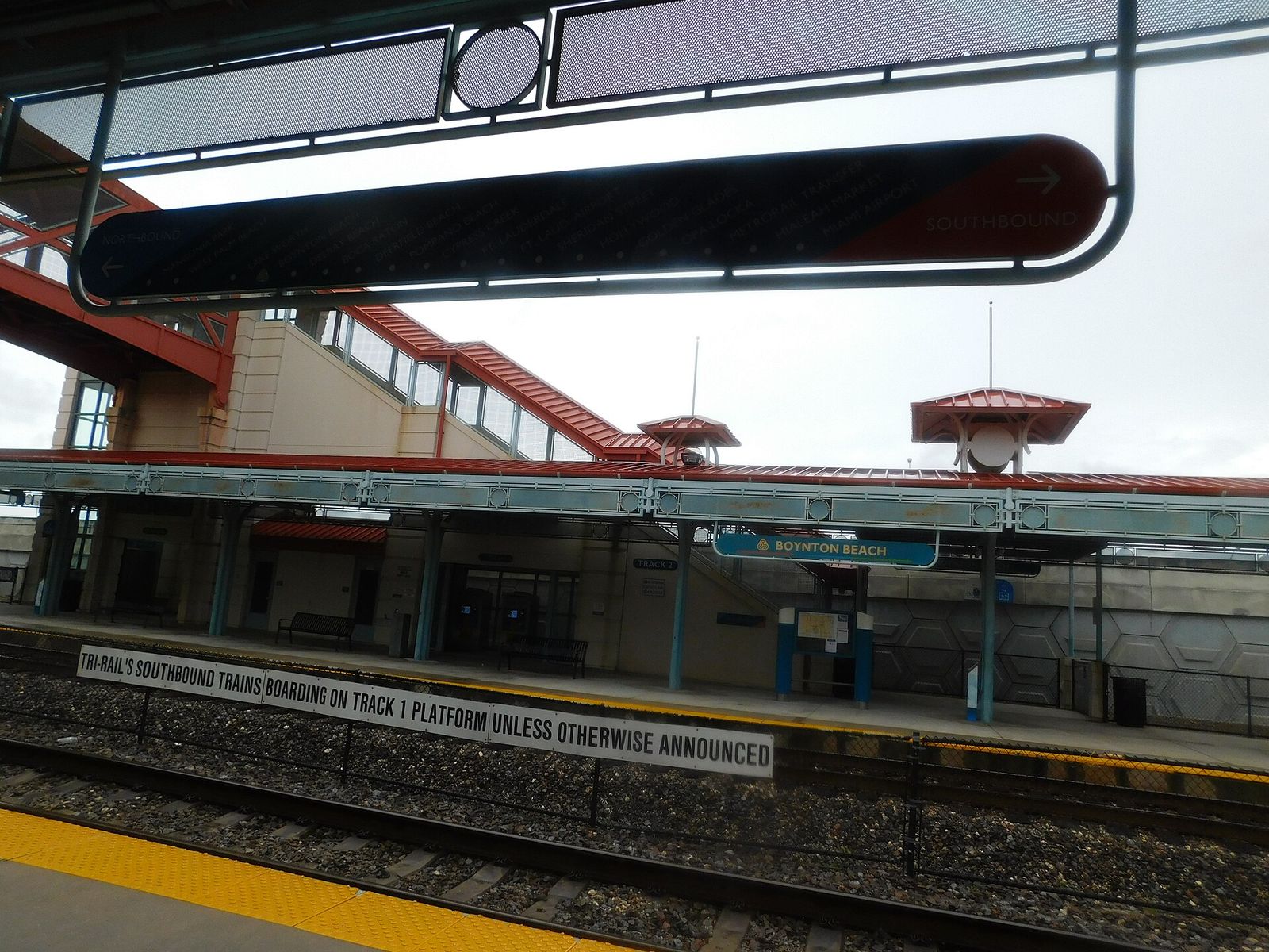 The platform canopy and track at the Boynton Beach Tri-Rail station, with a sign reminding riders which track to use