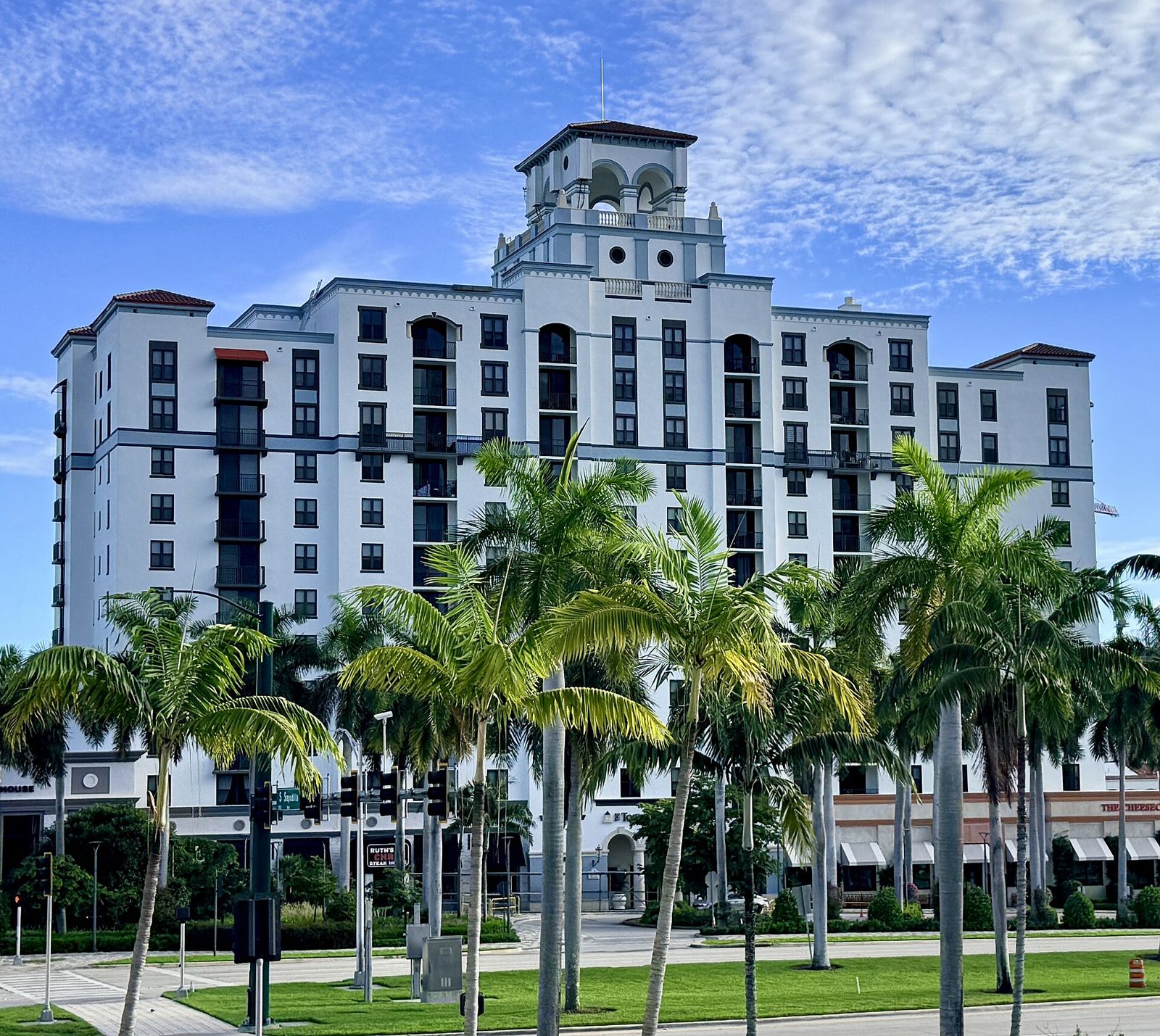 A tall condominium tower behind palm trees in West Palm Beach