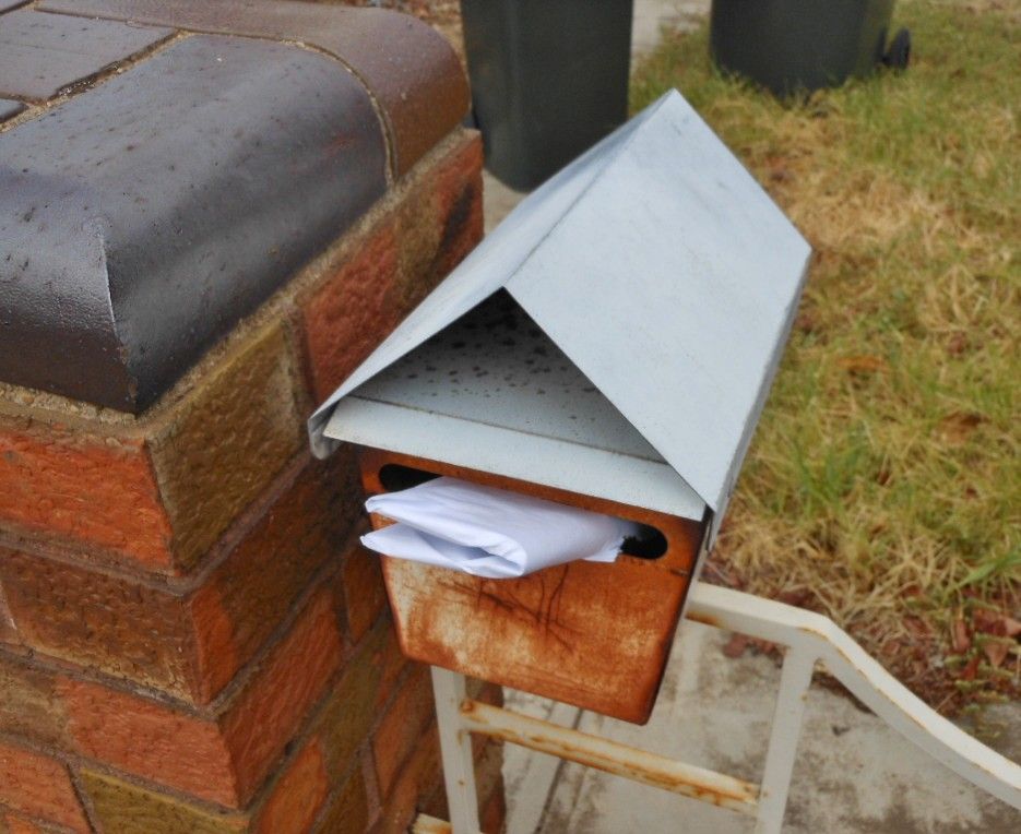 A weathered metal letter box
