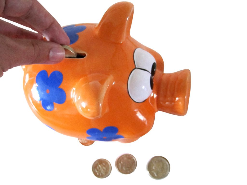 A pink piggy bank with coins