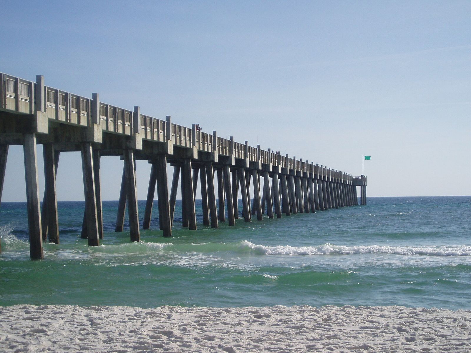 The long Gulf pier at Pensacola Beach over green water