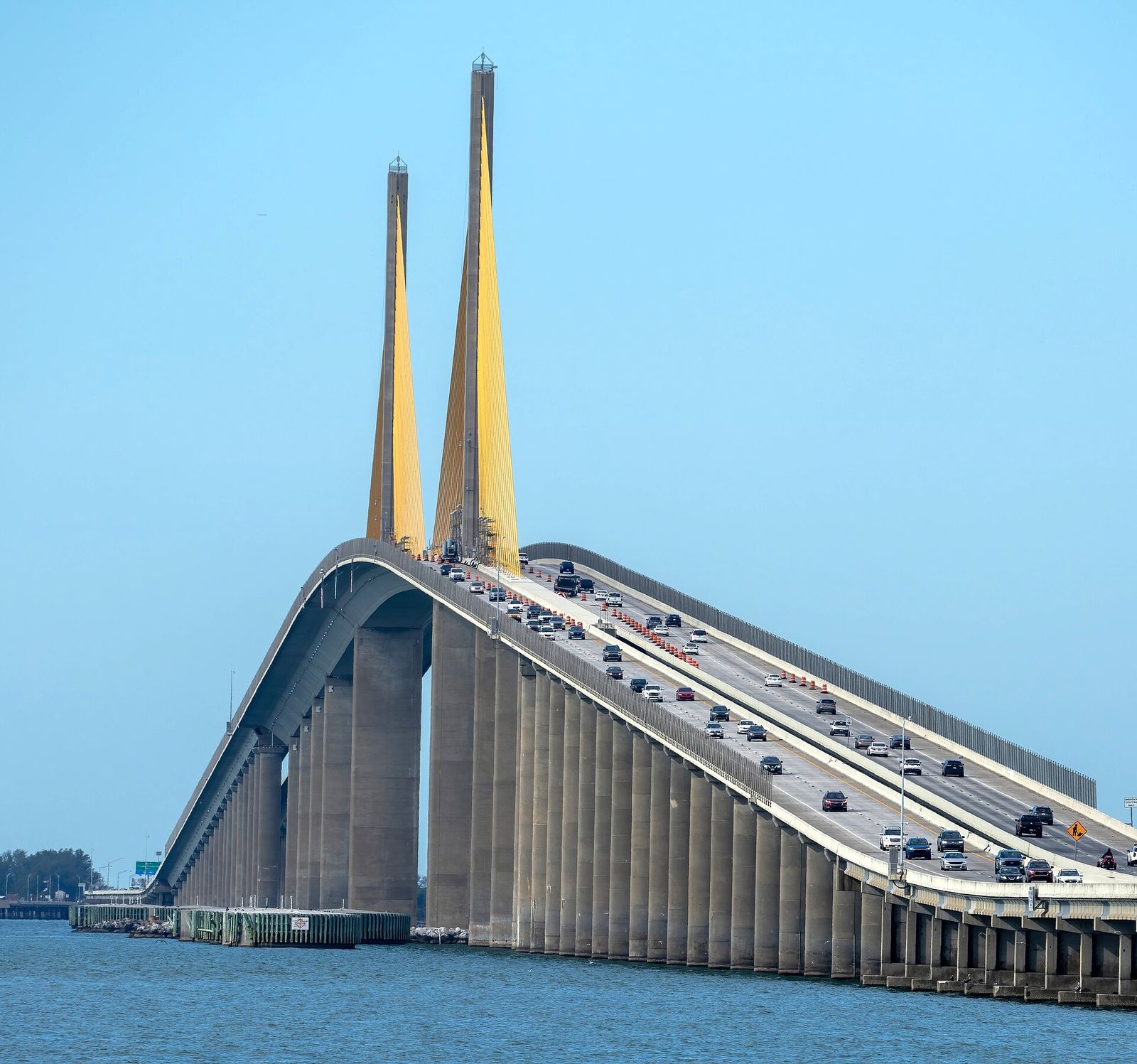 The yellow cable-stayed towers of the Sunshine Skyway Bridge rising over Tampa Bay south of St. Petersburg