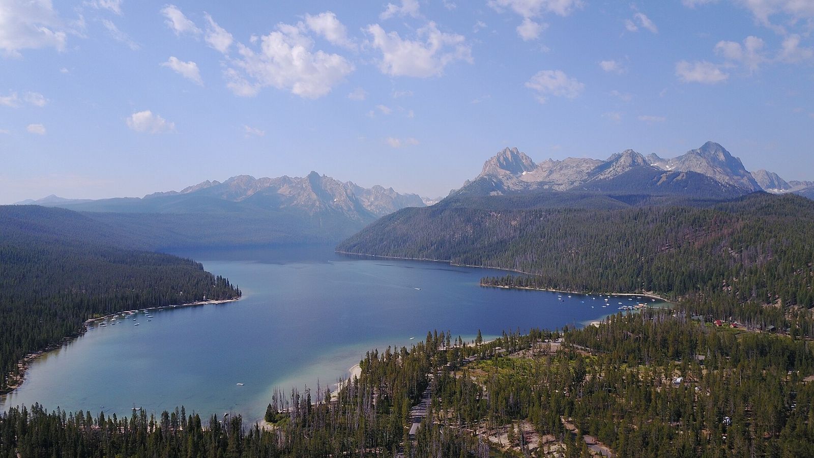 Redfish Lake stretching toward the Sawtooth Range, seen from a forested ridge