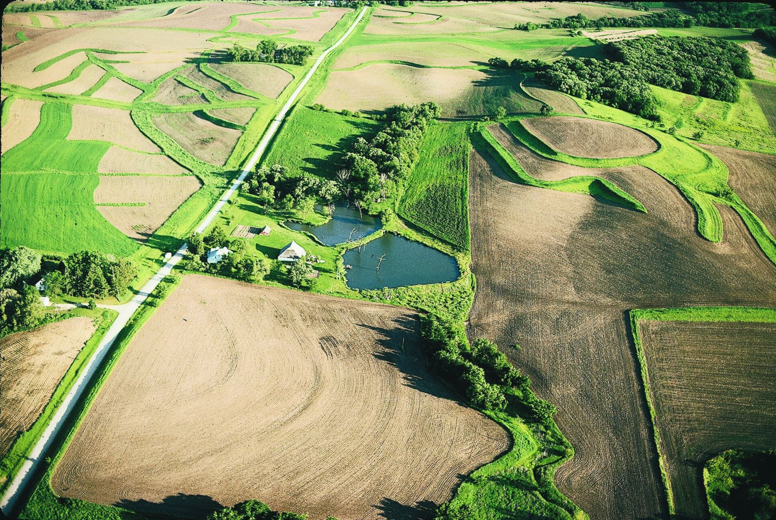 Aerial view of contoured farm fields, grassed waterways and small ponds among the Loess Hills of western Iowa