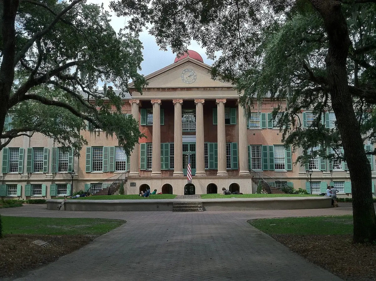 Randolph Hall, the main academic building at the College of Charleston, at the end of a paved walk framed by live oaks