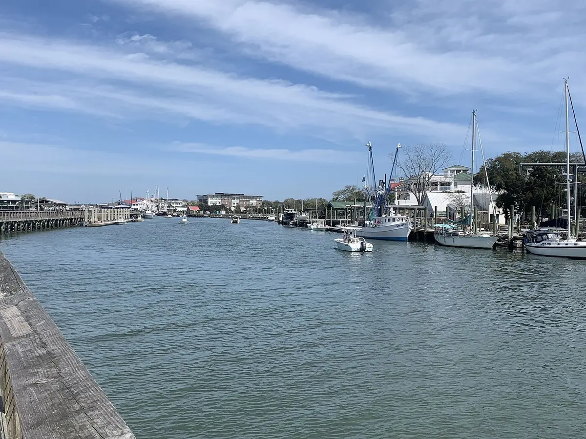 Boats tied up along the docks of Shem Creek in Mount Pleasant under a blue sky