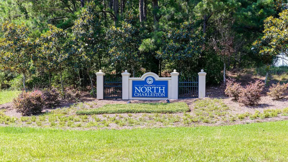 A Welcome to North Charleston sign in a landscaped bed beside eastbound Interstate 26