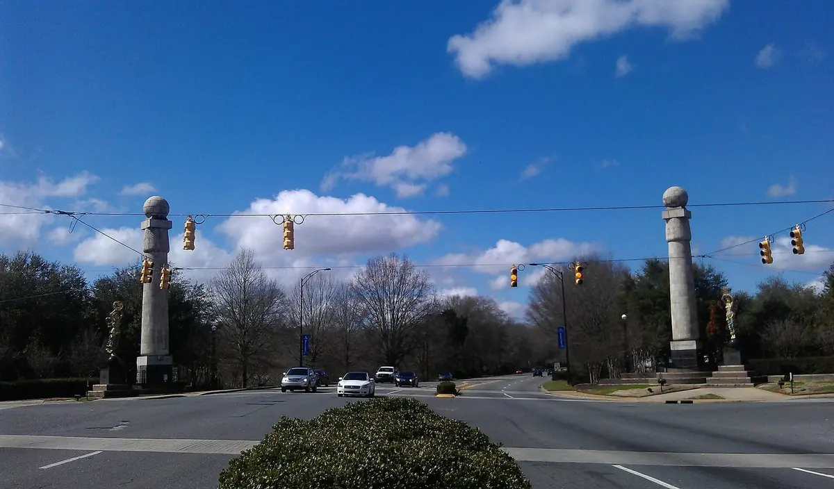 Tall columns at the Gateway intersection in Rock Hill, with traffic signals and trees under a blue sky