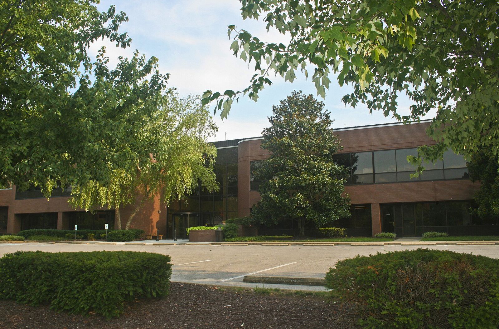Brentwood's brick town hall behind trees and a landscaped lawn