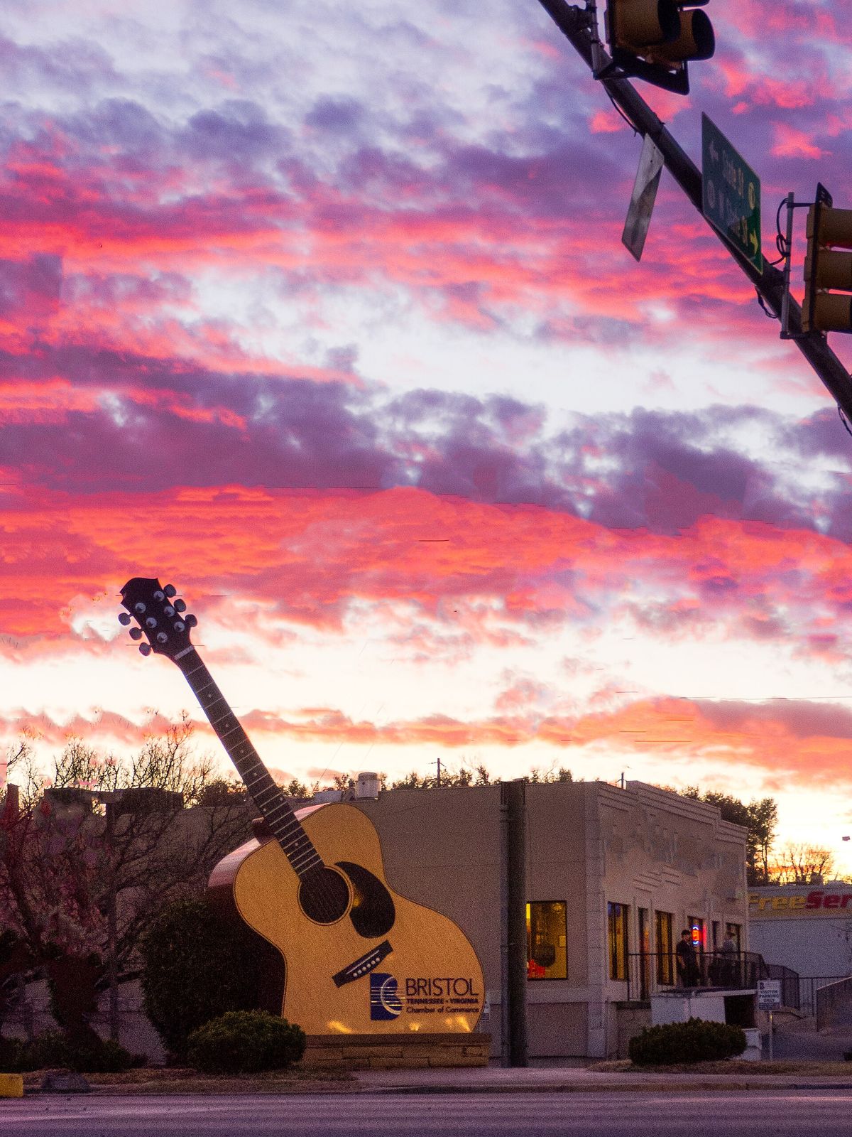 A giant guitar sculpture at State Street and Volunteer Parkway under a pink sunset