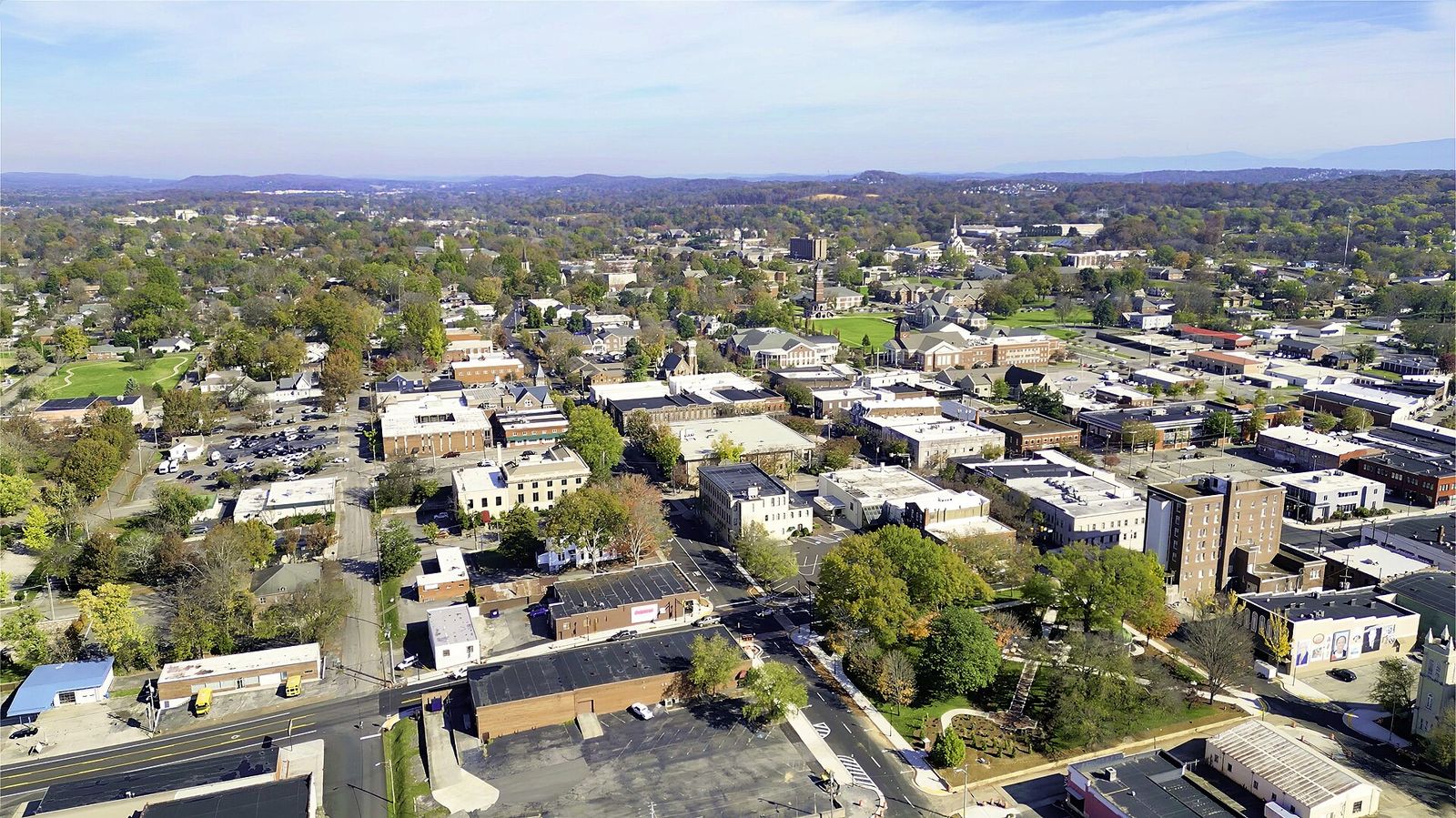 Aerial view of downtown Cleveland with tree-lined streets and hills beyond