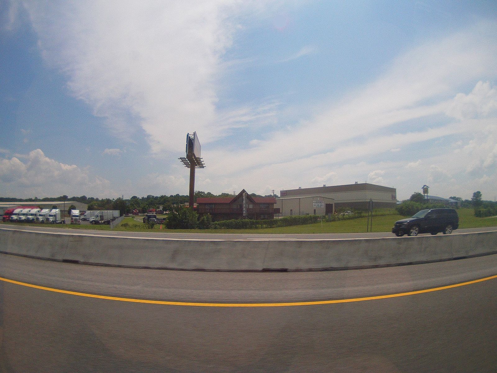 A wide roadside view along a La Vergne highway under summer clouds