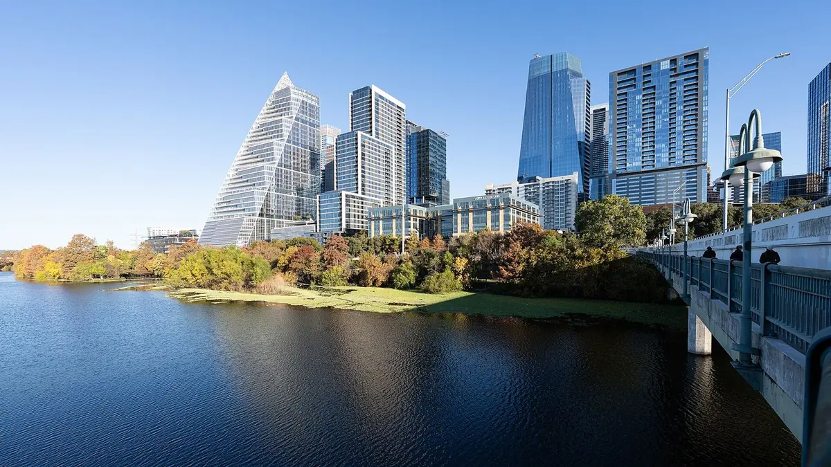 Downtown Austin high-rises along Lady Bird Lake, with the Ann W. Richards Congress Avenue Bridge at the right