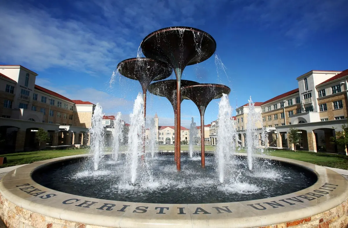 The Frog Fountain at Texas Christian University, its basin rim lettered with the university's name, in front of campus buildings