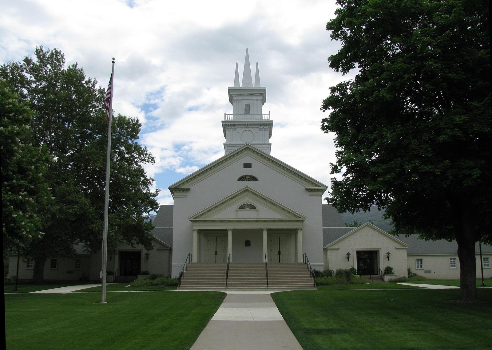 The white Bountiful Tabernacle with its pointed steeple, framed by tall trees