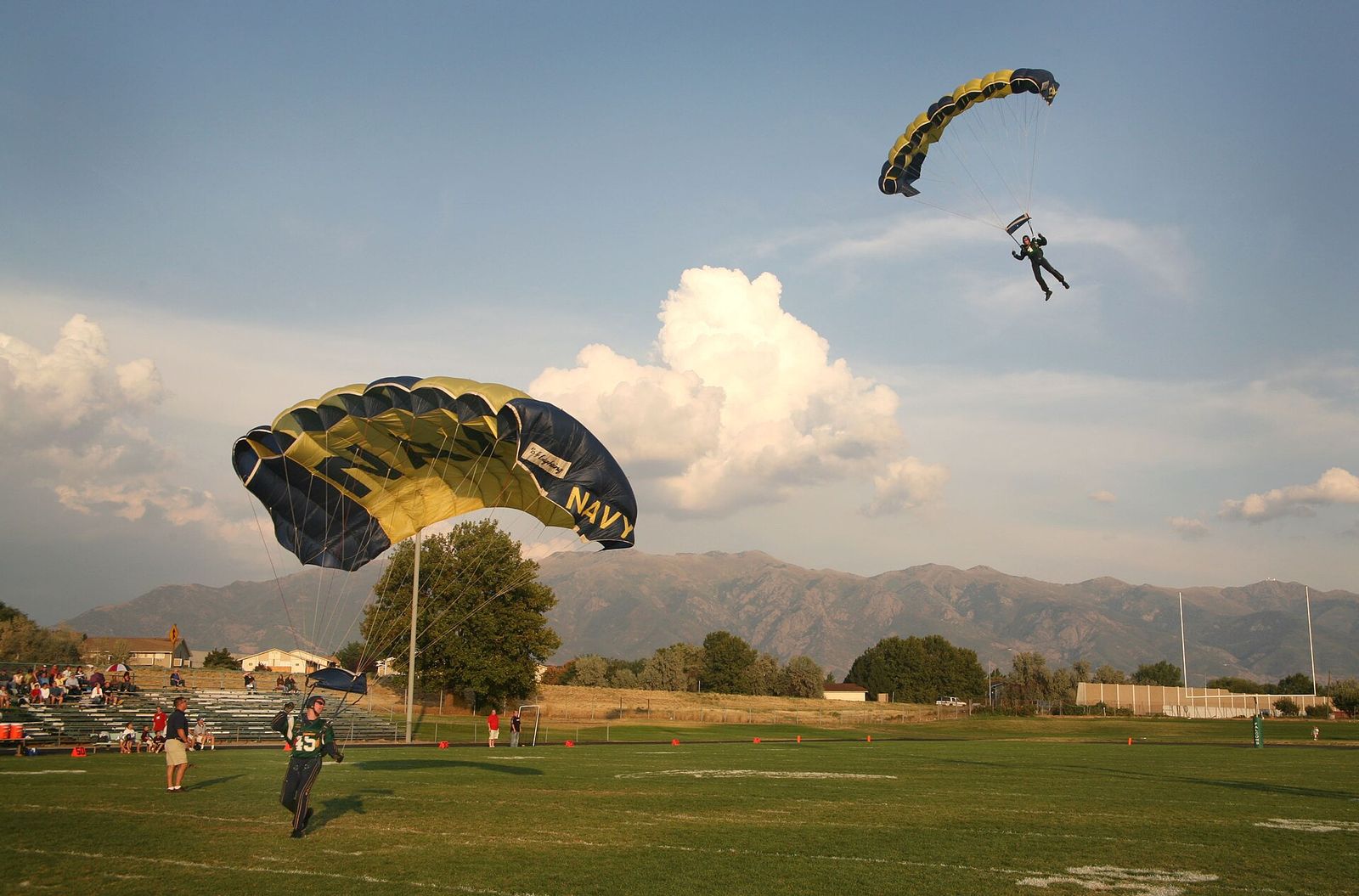 Navy Leap Frogs parachutists gliding down onto the Clearfield High School football field before a game