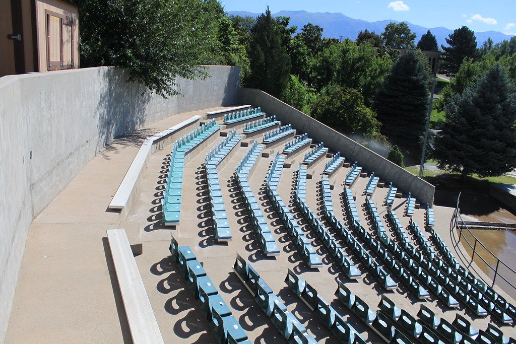 Curved rows of blue outdoor theater seats in Clearfield, with trees and mountains behind