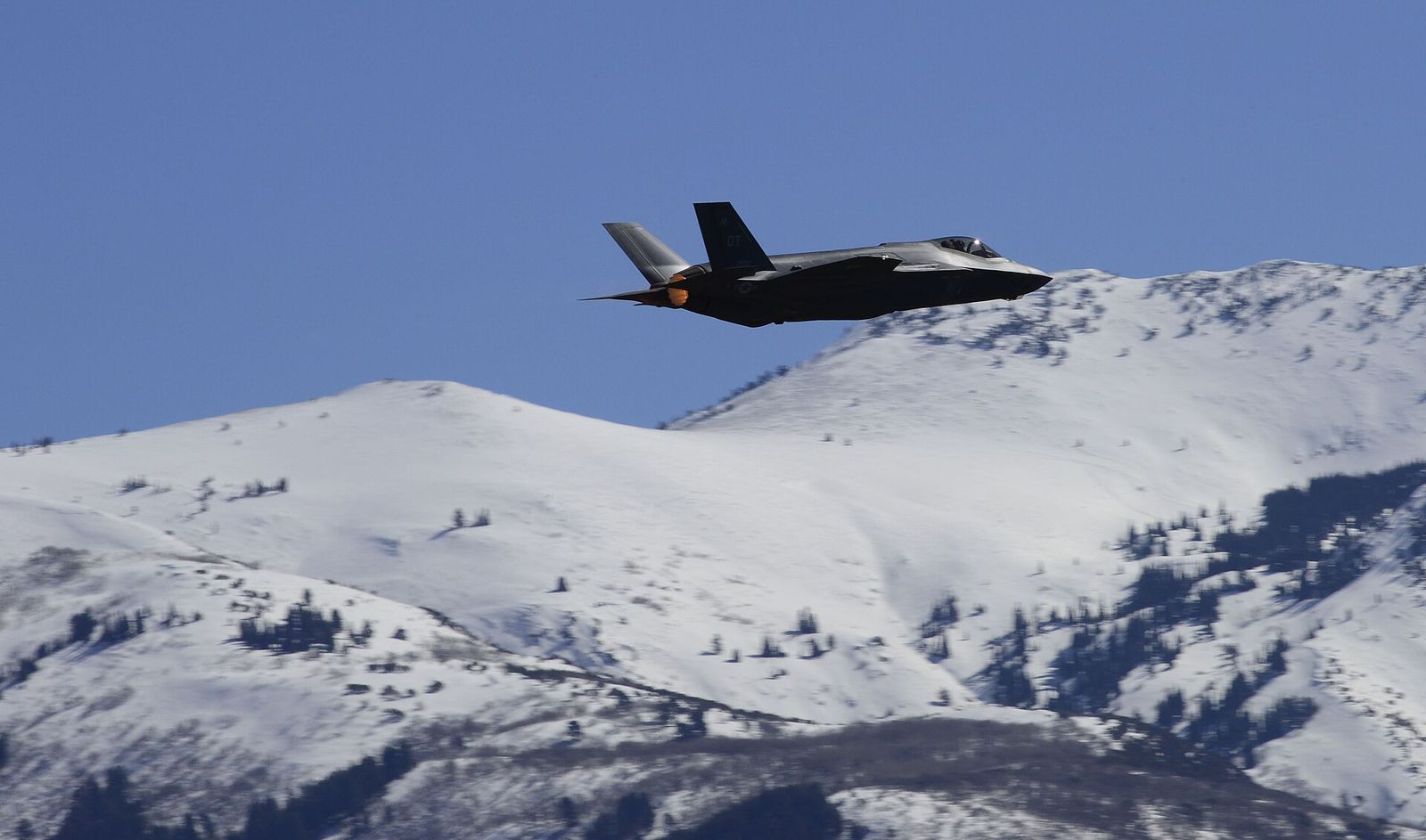 An F-35A jet flying above snowy hills at Hill Air Force Base in northern Davis County