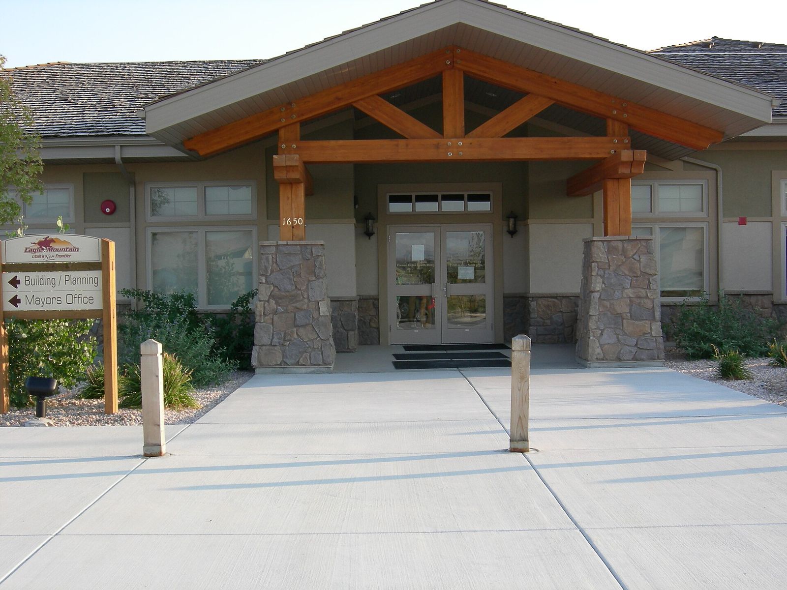 The entrance of Eagle Mountain City Hall, with timber beams and stone pillars over the doors
