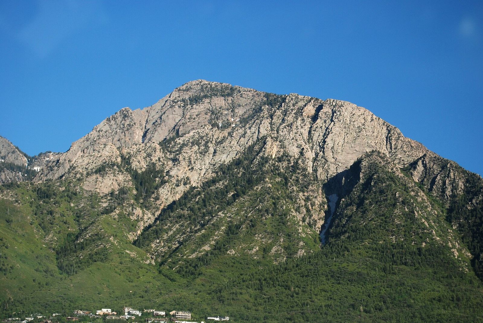 The rocky northwest face of Mount Olympus rising above green slopes on the Wasatch Front