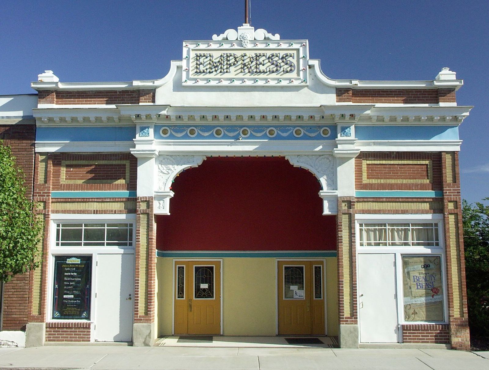 The white facade and arched red entrance of the Empress Theatre on Magna's Main Street