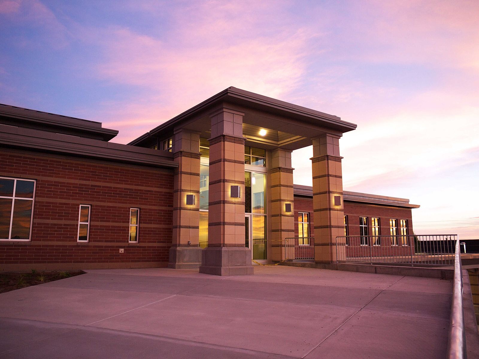 North Salt Lake City Hall, a brick and stone building with a tall entrance, under a pink evening sky
