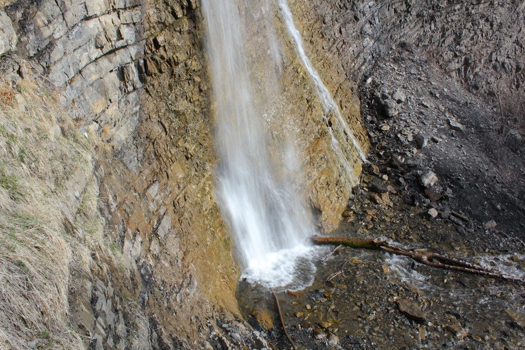 Battle Creek Falls spilling down a tall rock face above Pleasant Grove