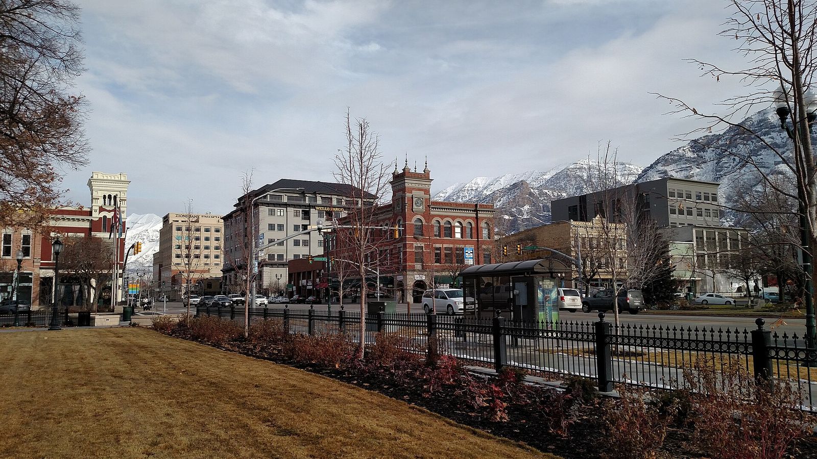 Historic brick buildings along a downtown Provo street with mountains behind