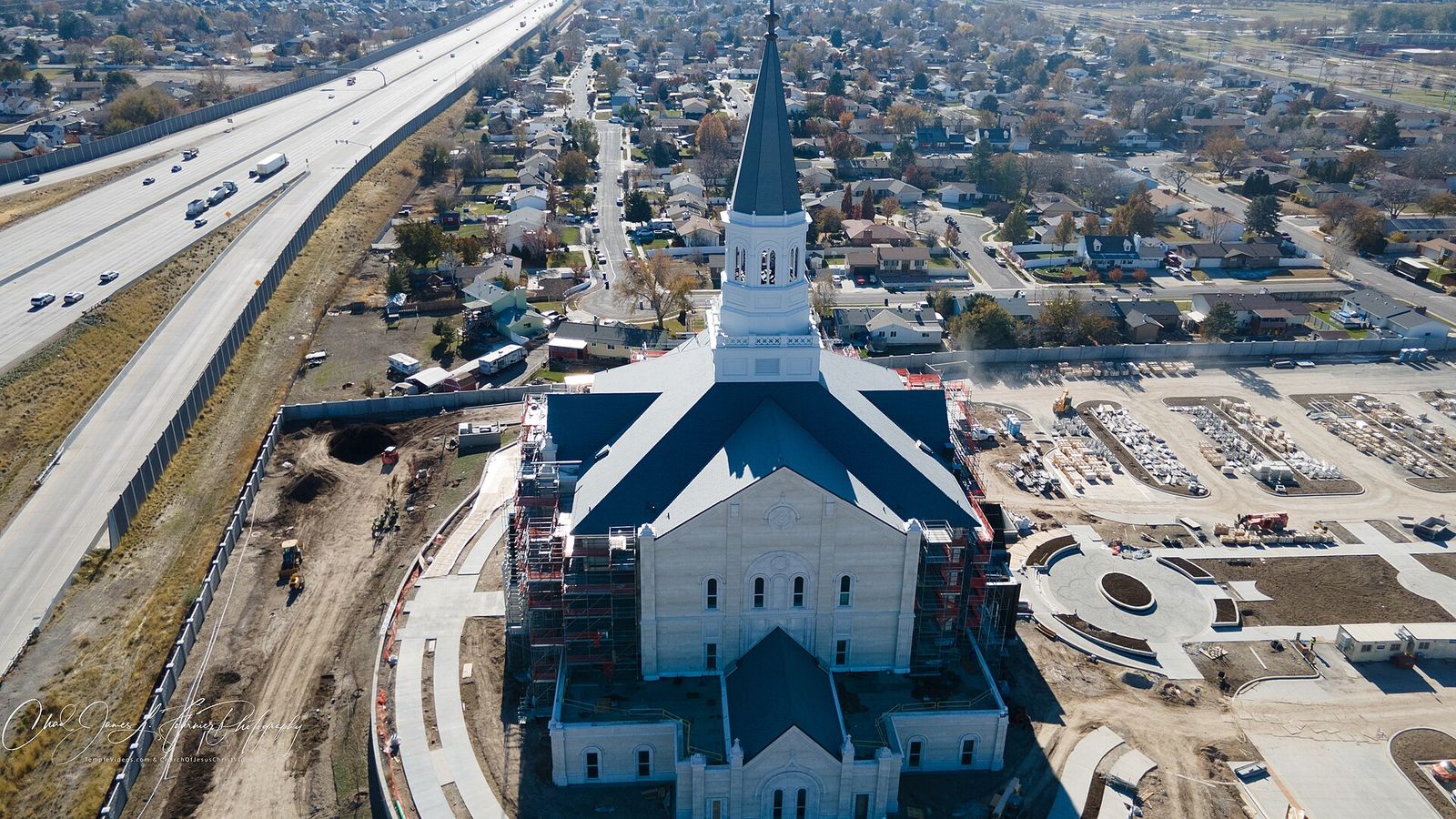 Aerial view of the Taylorsville temple under construction in 2022 next to Interstate 215