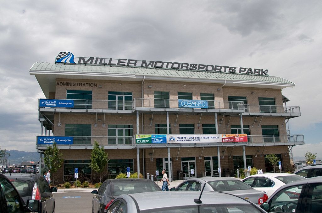 The four-story Miller Motorsports Park building in Tooele with cars parked in front