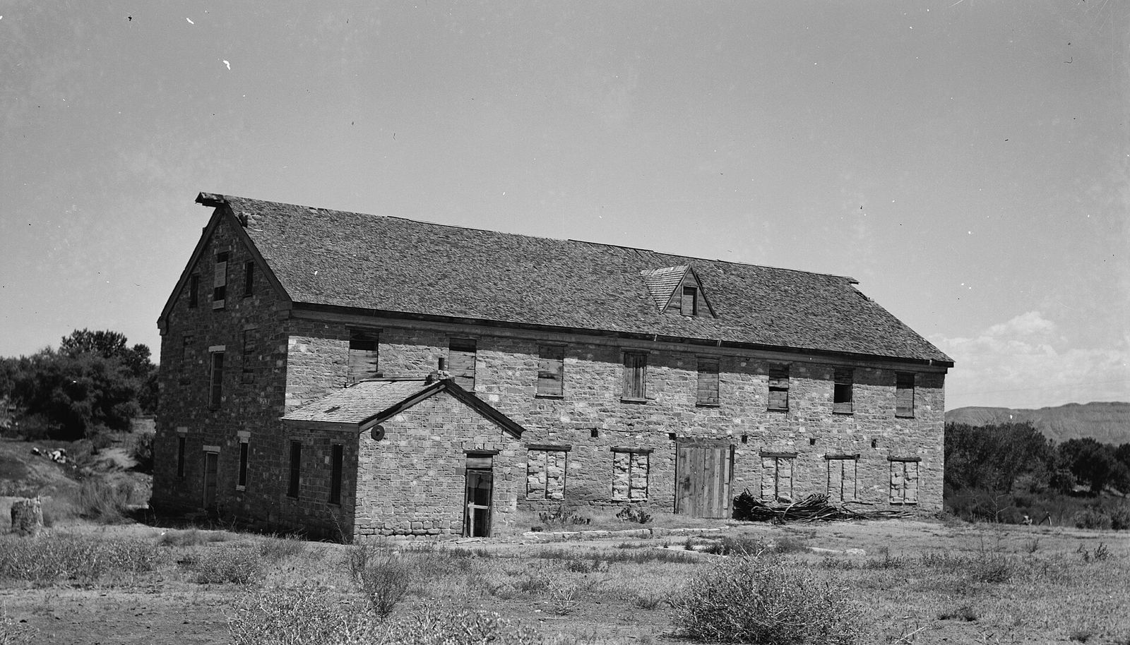The long two-story stone Washington Cotton Factory with a pitched roof, in an old black-and-white photograph