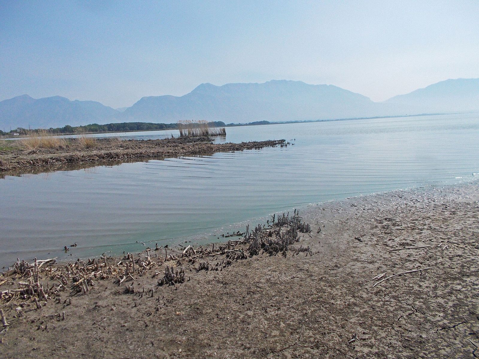 The start of the Jordan River where it leaves Utah Lake, with mountains across the water