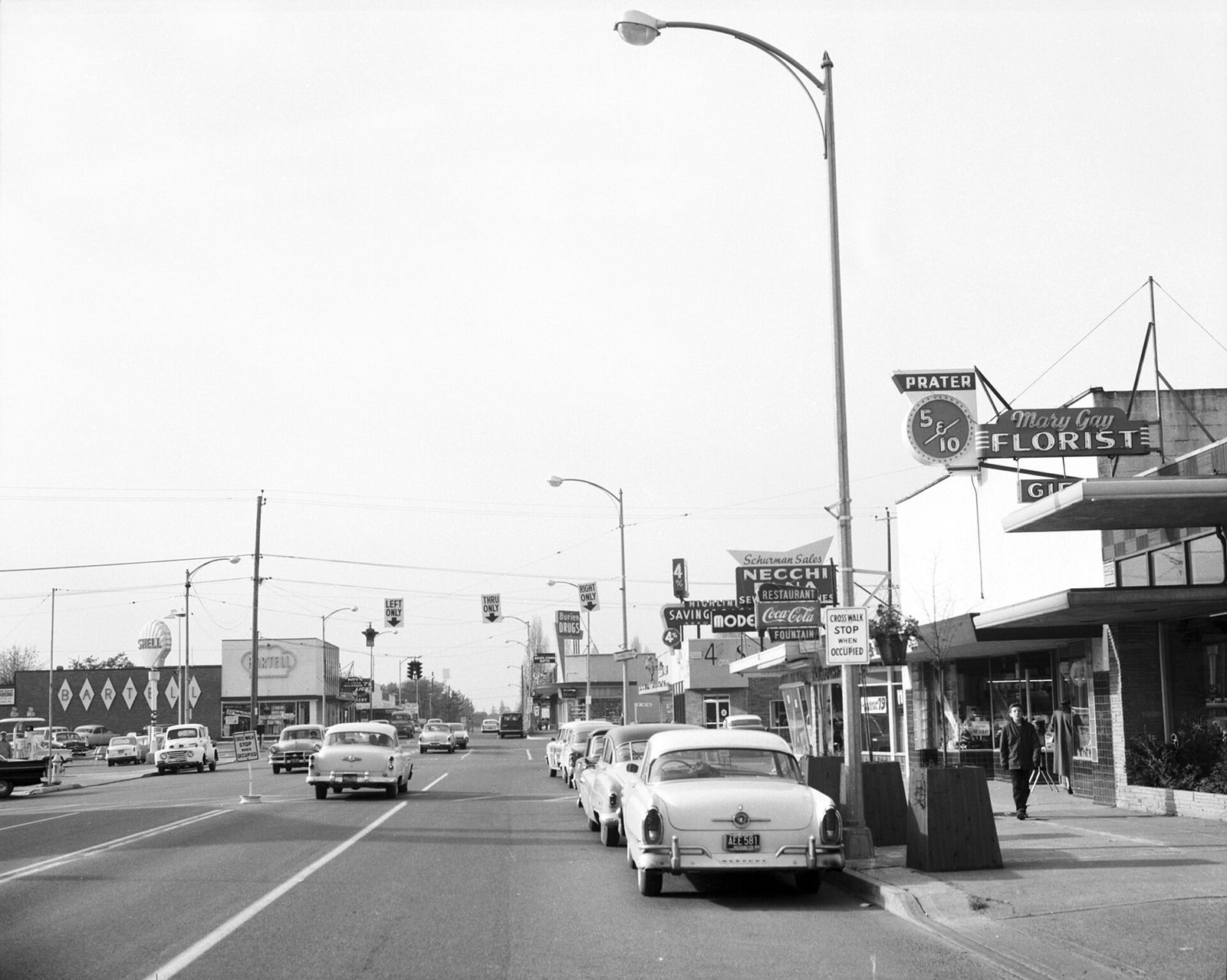 Cars and shops along SW 152nd Street in Burien around 1960
