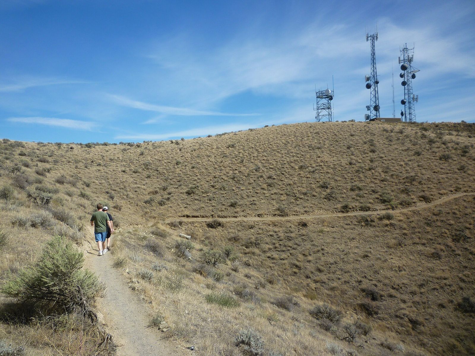 A hiker on a dry hillside trail on Badger Mountain above the Tri-Cities