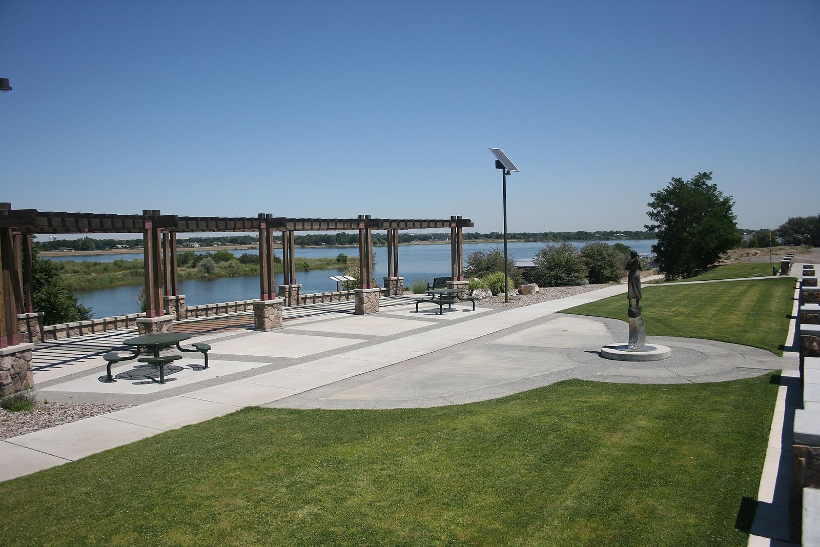 A riverside park path looking across the Columbia River toward Pasco